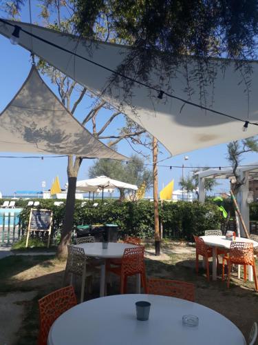 贝拉里亚-伊贾马里纳贾尔迪诺公寓式酒店的一组桌子和椅子,放在白色伞下