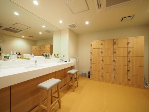 仓敷Tabino Hotel Kurashiki Mizushima的一间带大水槽和木制橱柜的浴室