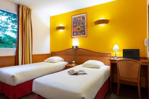 岩尼维利B&B HOTEL Amneville-les-Thermes的酒店客房配有两张床和一张书桌