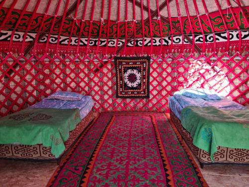 Ak-SayFeel Nomad Yurt Camp的红色蒙古包内带两张床的房间