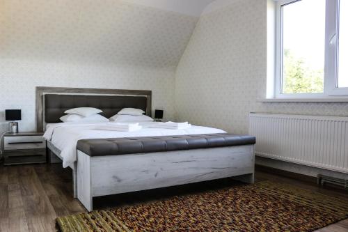 斯伽尔达Krusttēvu māja的一间卧室配有一张带白色床单的床和一扇窗户。