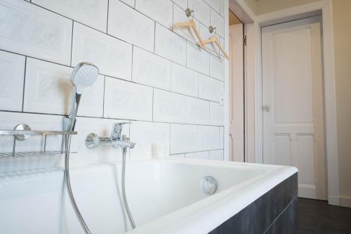 布鲁日Castle ten Berghe Château的浴室设有带淋浴头的白色浴缸。