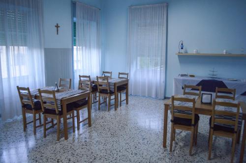 卡瓦德蒂雷尼La fontana de li Papi的一间设有桌椅的用餐室,墙上有十字架