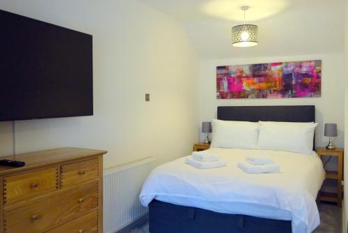 马特洛克Derwent View Holiday Apartments的一间卧室设有一张带平面电视的床。