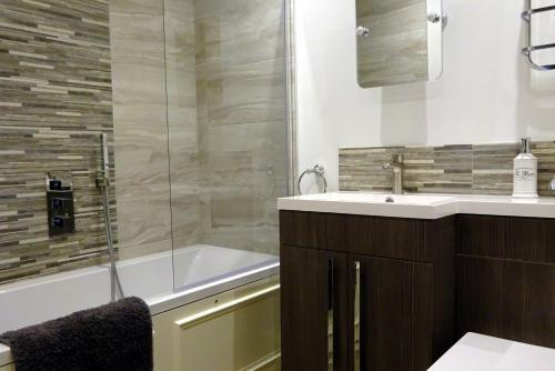 马特洛克Derwent View Holiday Apartments的带浴缸、水槽和淋浴的浴室