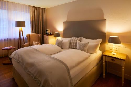 蒂门多弗施特兰德罗曼蒂克负和淄博酒店的酒店客房带一张大床和一把椅子