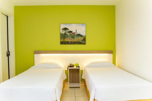 库里提巴Bristol Upper Curitiba Alto da XV的绿墙客房内的两张床