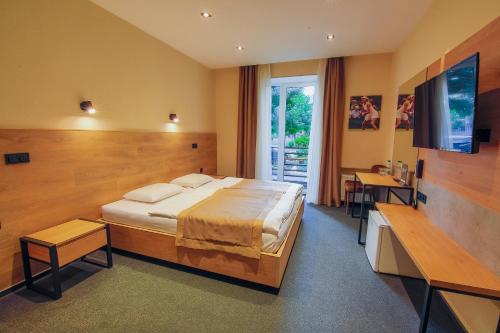 切尔卡瑟Sport Hotel的一间卧室配有一张大床和电视