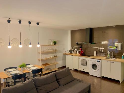 阿利坎特Mush Rooms Apartments的带沙发和桌子的客厅以及厨房。