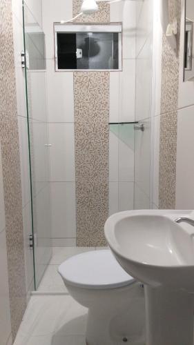 瓜拉图巴Pousada Verdes Mares guaratuba的白色的浴室设有水槽和卫生间。
