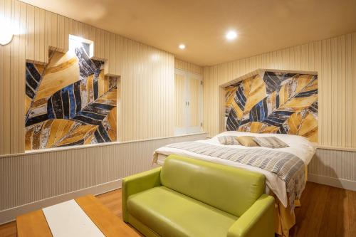 丰山ロコガーデン小牧的一间卧室配有一张床和一张绿色沙发