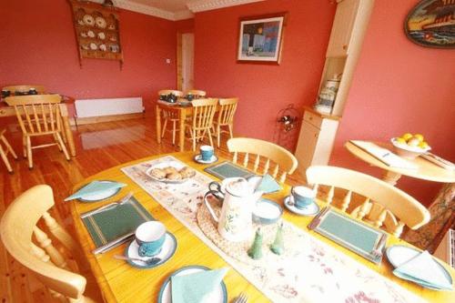 斯尼姆Sneem River Lodge Bed & Breakfast的一间带桌椅的用餐室和一间餐厅