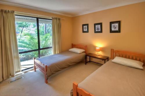 黑荒地卡米洛度假屋的一间卧室设有两张床和大窗户