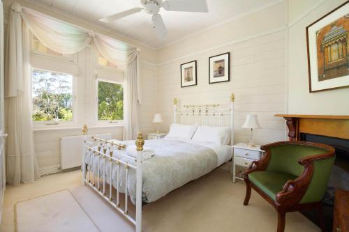 黑荒地赫斯蒙度假屋的卧室配有白色的床和绿色椅子