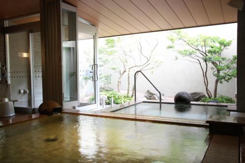 鱼津鱼津门通站前酒店的设有一个浴缸的大窗户