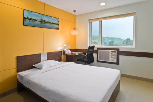 阿加尔塔拉姜阿加尔塔拉旅馆的一间卧室配有一张床、一张书桌和一个窗户。