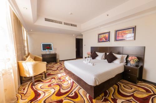 阿吉曼阿吉曼伊万套房酒店的配有一张床和一把椅子的酒店客房