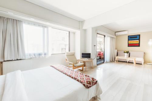 雅典雅典一室公寓的白色卧室配有床和书桌