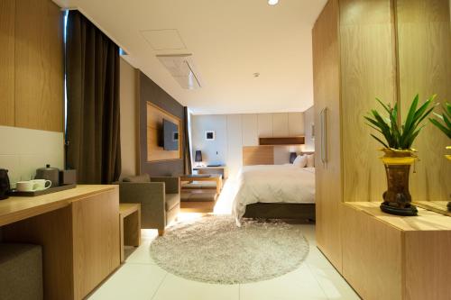 首尔日安酒店的一间卧室设有一张床和一间客厅。