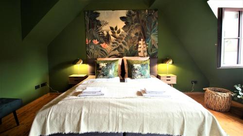 维尔茨堡The George Rooms - Boutique Style的卧室配有一张大床,墙上挂有绘画作品