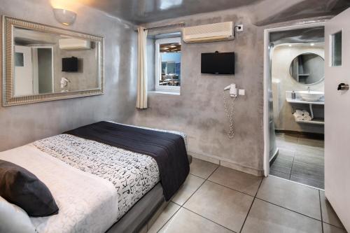 易莫洛林Katerina's Castle - Caldera Cave Hotel的一间卧室配有一张床,浴室设有水槽