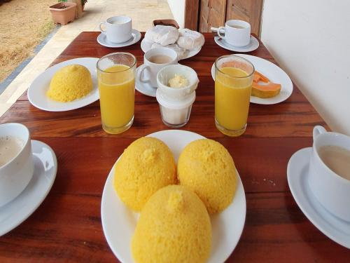 巴纳伊巴Pousada Vila Cajuína - Parnaíba的餐桌,盘子上放着食物和橙汁
