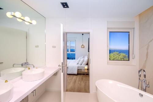耶塞尼采Villa Lipa的白色的浴室设有两个盥洗盆和窗户。
