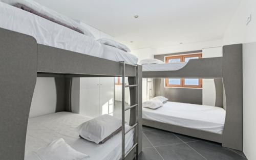 雷克罗塞Refuge Le Marcheuson的白色墙壁的客房内设有两张双层床。