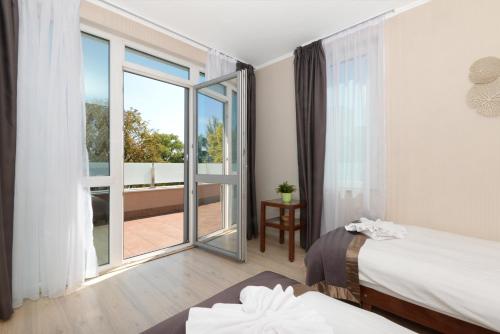 布达佩斯布达佩斯假日海滩疗养及桑拿公园酒店的酒店客房设有两张床和一个阳台。