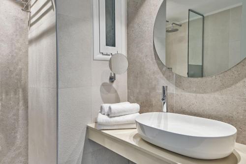 马斯蒂查里Atlantica Marmari Palace的浴室设有白色水槽和镜子