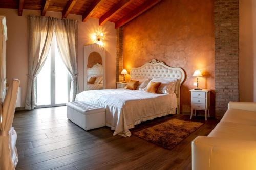 蒙蒂基亚里Agriturismo le Fontanelle da Valente的卧室设有白色的床和大窗户
