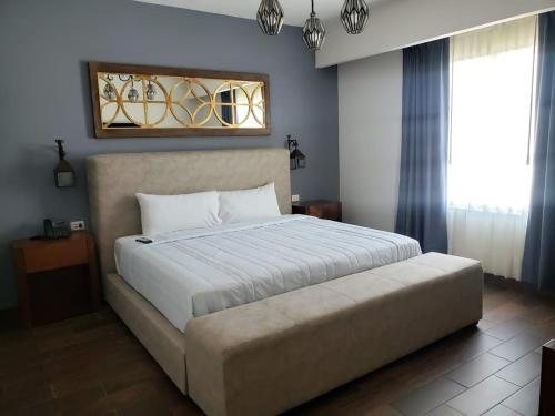 MatamorosHOTEL PLAZA MATAMOROS的卧室配有一张白色的大床和一张沙发。