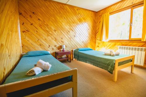 埃尔卡拉法特Bla Guest House的木制客房内的一间卧室配有两张床