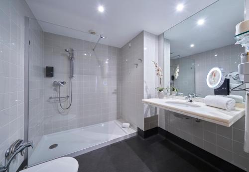 丰沙尔金色公馆酒店的带淋浴、盥洗盆和浴缸的浴室