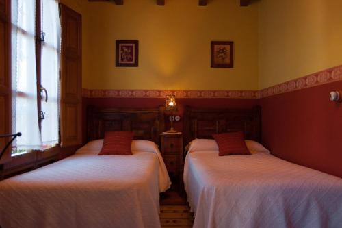 CamocaCasa Lolo de Villaviciosa的配有两张床铺的黄色墙壁和窗户