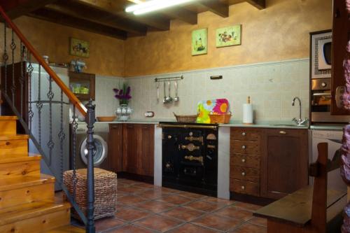 CamocaCasa Lolo de Villaviciosa的一间带炉灶和水槽的厨房以及楼梯