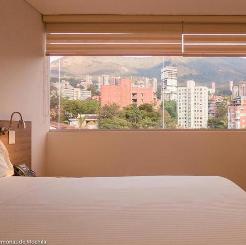 麦德林Hotel Lomas 10的卧室设有窗户,享有城市美景