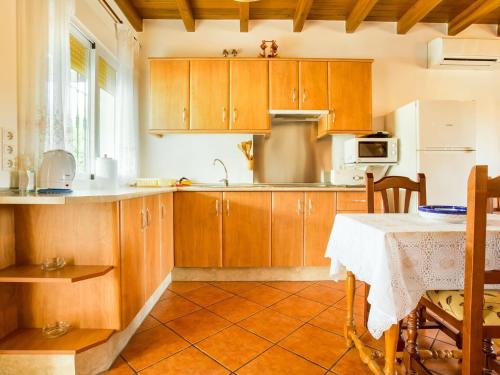古罗Belvilla by OYO La Vista的厨房配有木制橱柜和带桌布的桌子。