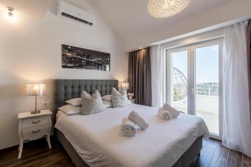赫瓦尔Hvar de luxe apartments 1的卧室配有带毛巾的大型白色床