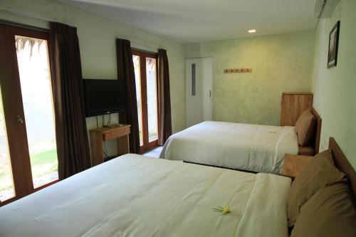 巴图卡拉巴尔卡郎别墅的酒店客房设有两张床和电视。