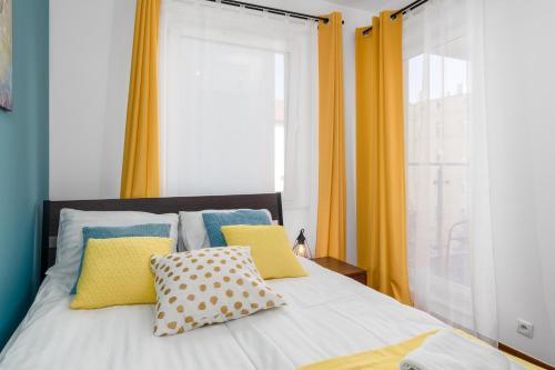 波兹南Sleepway Apartments - Garbary 95-75D的一间卧室配有黄色窗帘的床