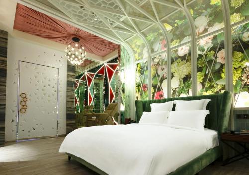 高雄御宿汽车旅馆中华馆的一间卧室设有一张带花卉墙壁的大床