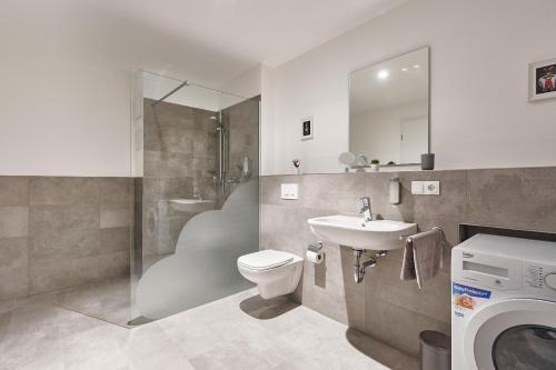 弗莱堡The Cloud Suite Apartments的浴室配有卫生间、盥洗盆和洗衣机。