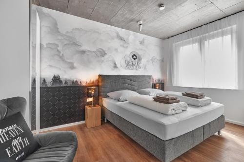 弗莱堡The Cloud Suite Apartments的一间卧室设有两张床,墙上挂着一幅画