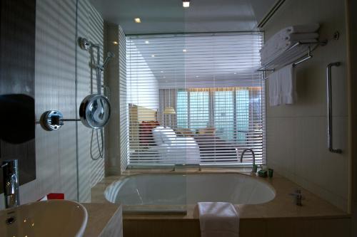 阿布扎比亚斯岛皇冠假日酒店的带浴缸、水槽和窗户的浴室
