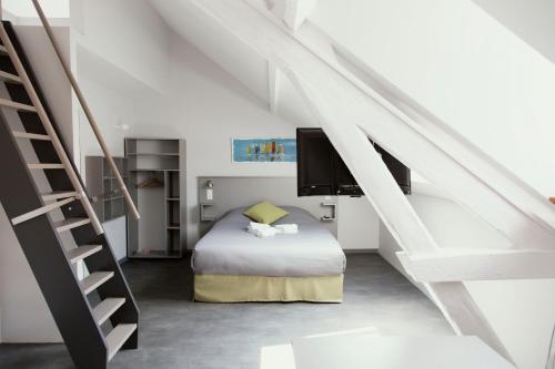 圣纳泽尔SmartAppart Saint Nazaire的一间卧室设有一张床和一个楼梯
