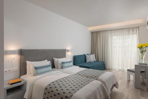 罗希姆诺Bio Suites Hotel & Spa的一间卧室配有一张大床和一张蓝色椅子
