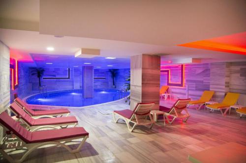 加济安泰普布尤克威力克酒店的客房设有带椅子和一组椅子的游泳池。