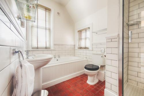 朴次茅斯佛罗伦萨花园精品酒店及餐厅的白色的浴室设有浴缸、卫生间和水槽。