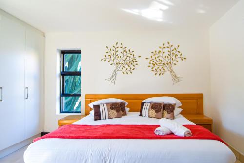杰米斯顿112 on Kloof Guesthouse的一间卧室配有一张带红色毯子的大床